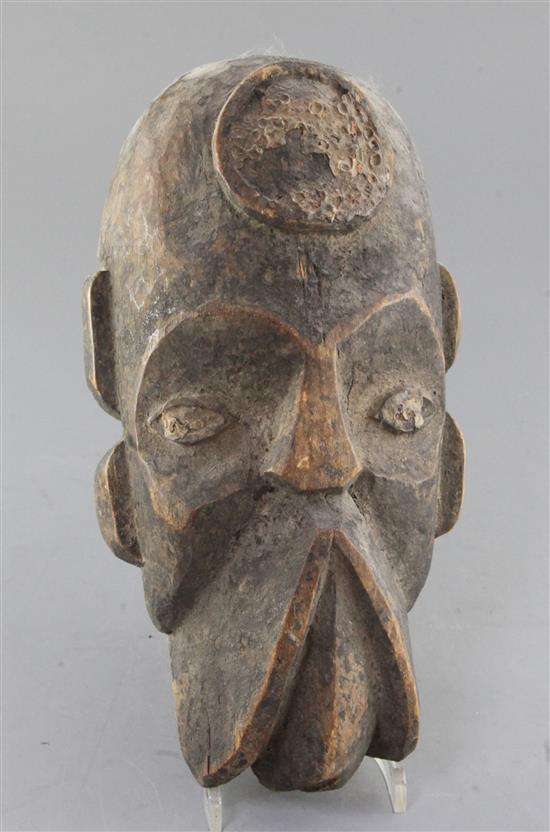 An African carved wood mask, with traces of applied decoration, 32cm